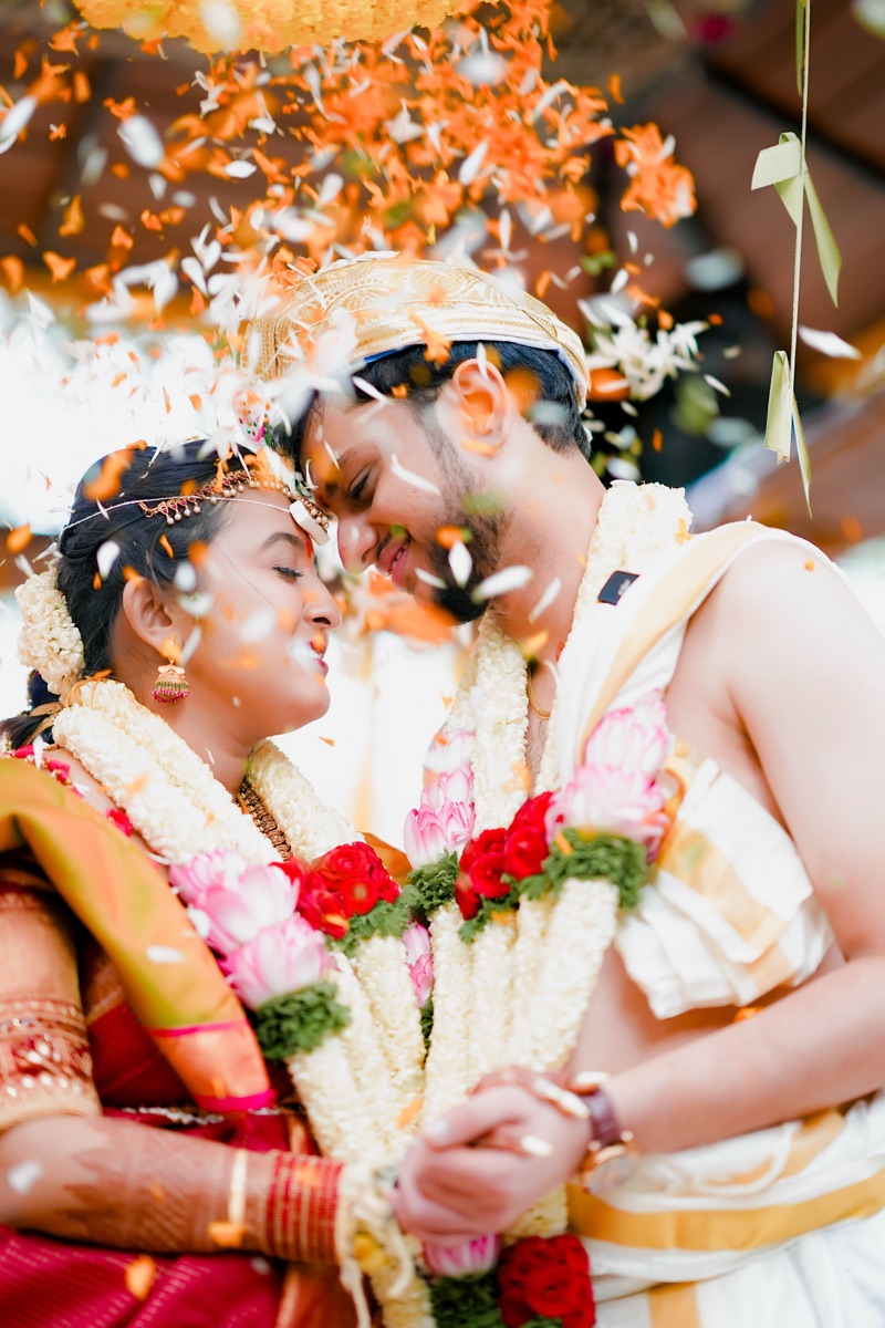 Bride and groom in a joyful petal-shower moment